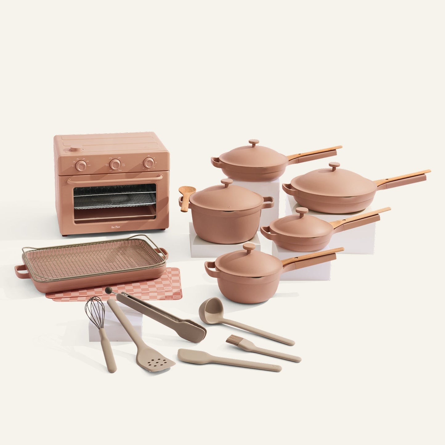 Set of pink cookware and kitchen appliances on a white background