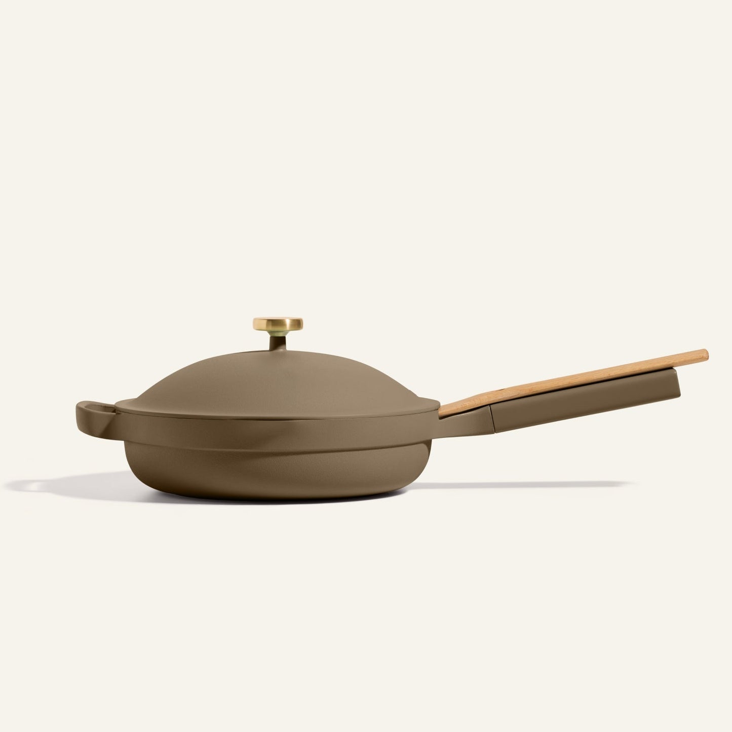 The Always Pan 2.0, a matte olive green nonstick frying pan with a lid plus wooden handle and knob, is shown on a plain light background—an essential from our bestselling cookware collection.