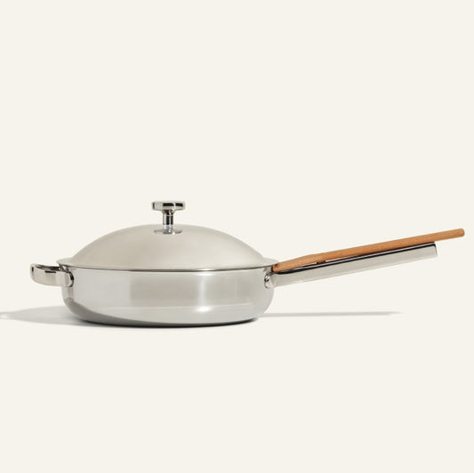 The Titanium Always Pan Pro features a domed lid, long wooden handle, short side handle, and no-coating nonstick technology—all showcased against a plain light background.