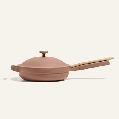 The Always Pan 2.0, a pink nonstick frying pan with a lid and light wooden handle, is showcased against an off-white background—ideal for your bestselling cookware lineup or as part of a versatile 10-in-1 system.