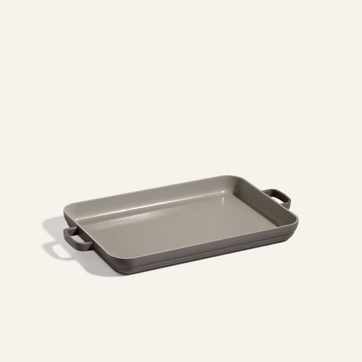 A rectangular gray Griddle Pan with nonstick coating and two handles is placed on a plain, light-colored background.