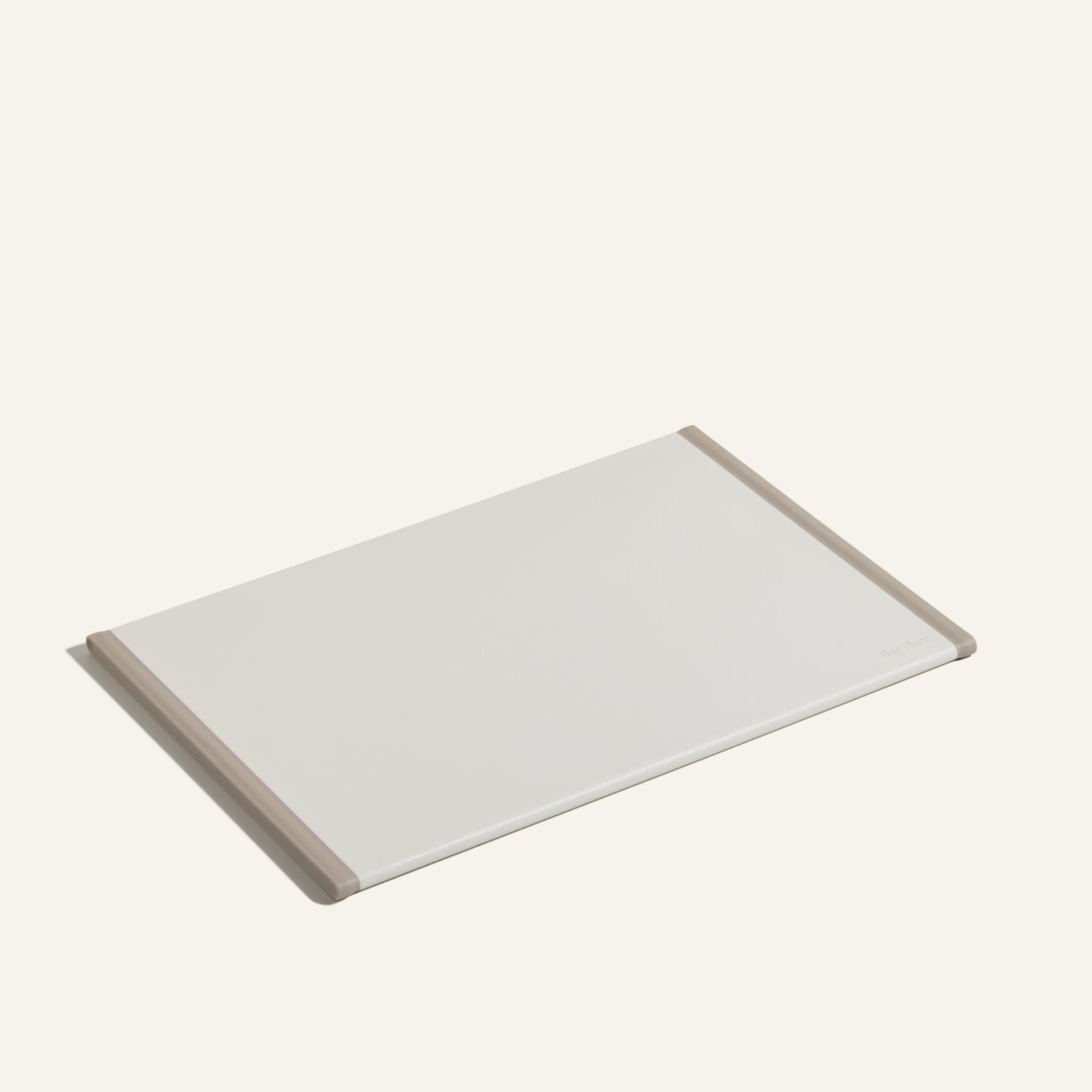 The Daily Board, a rectangular white cutting board with beige edges made from recycled materials, is displayed on a light background.