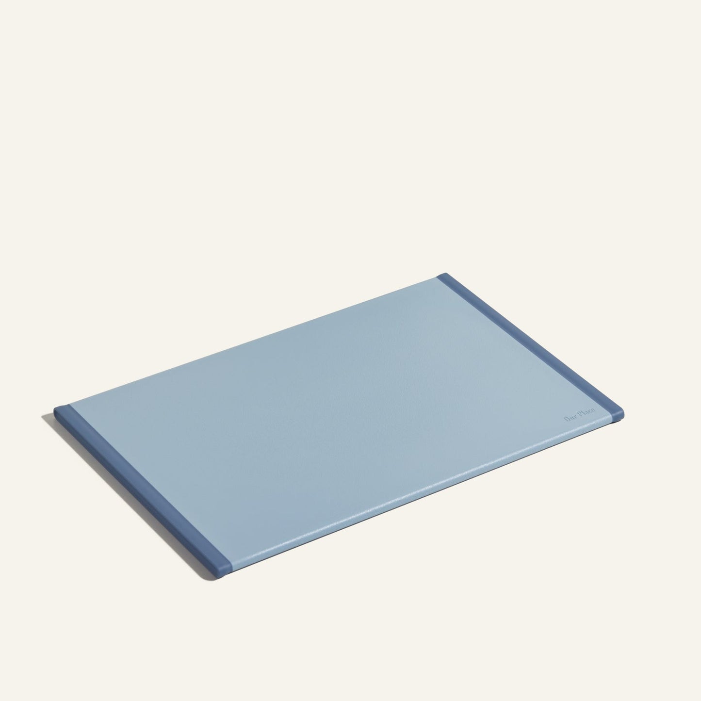 The Daily Board is a rectangular light blue cutting board with darker blue edges, made from recycled materials, shown on a light background.