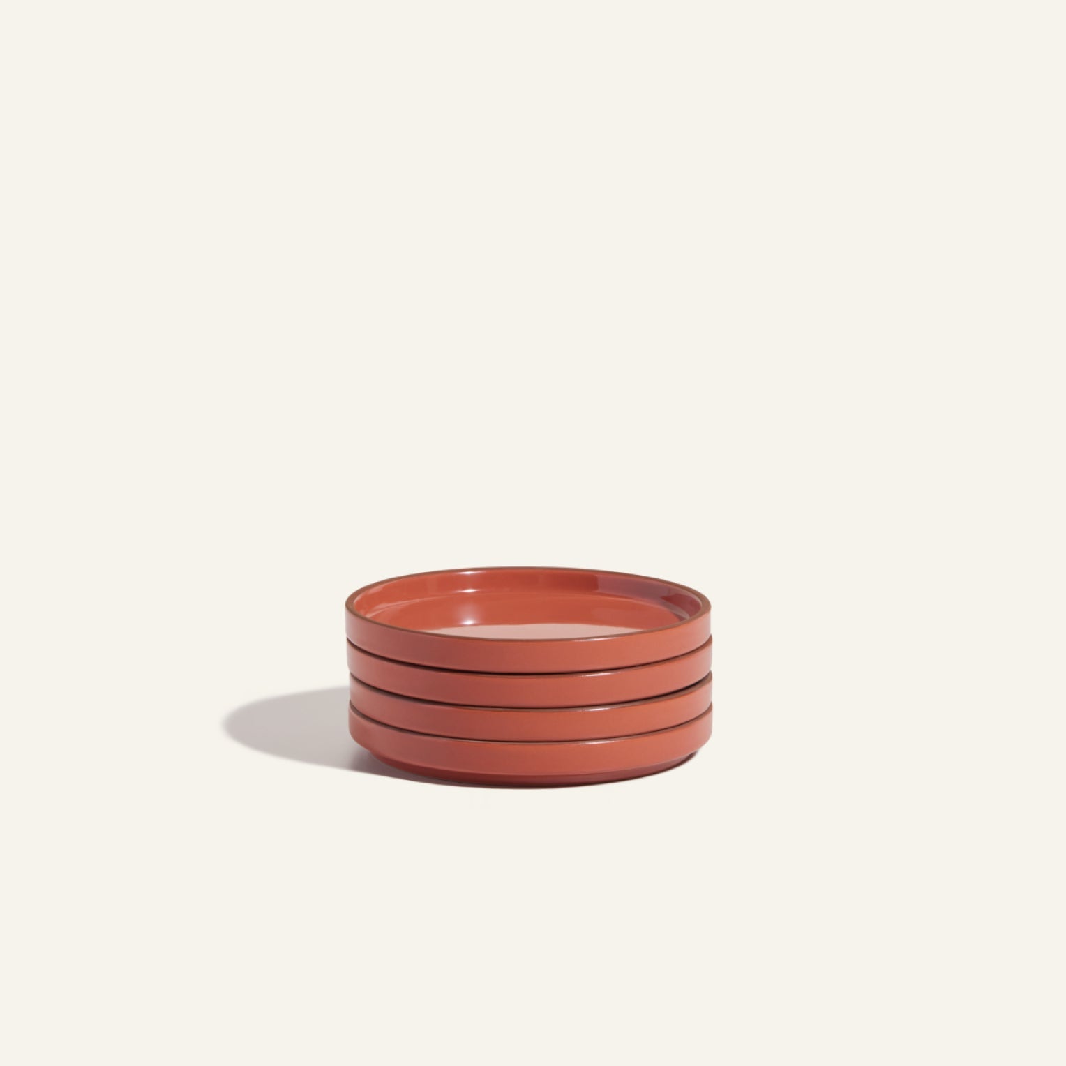 Set of three round, shallow Dessert Plates in a warm reddish-brown finish, arranged on a plain light background with a soft shadow to the left.