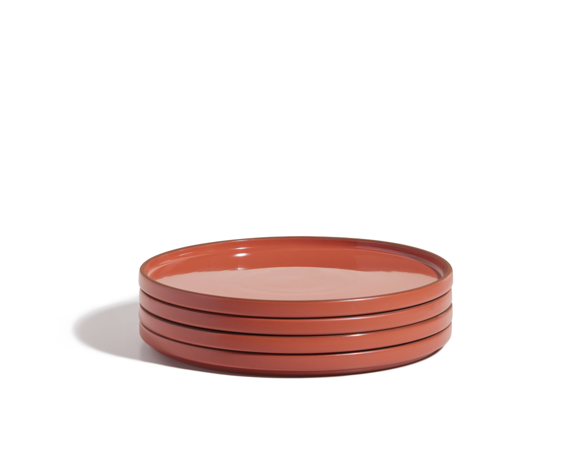 A stack of four round, red hand-glazed Dinner Plates on a white background—perfect for adding a vibrant touch to your tableware collection.