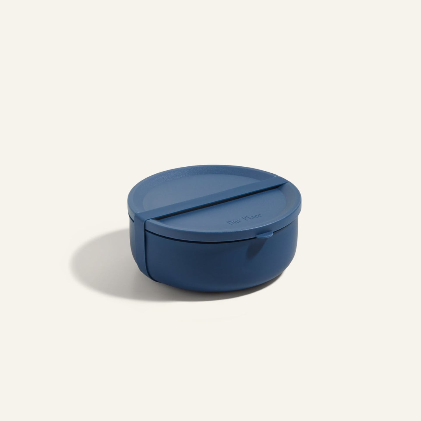 The Wander Bowl is a round, blue plastic lunch container with a fitted lid, shown against a plain background. Microwave safe, it's ideal for storing and reheating meals.