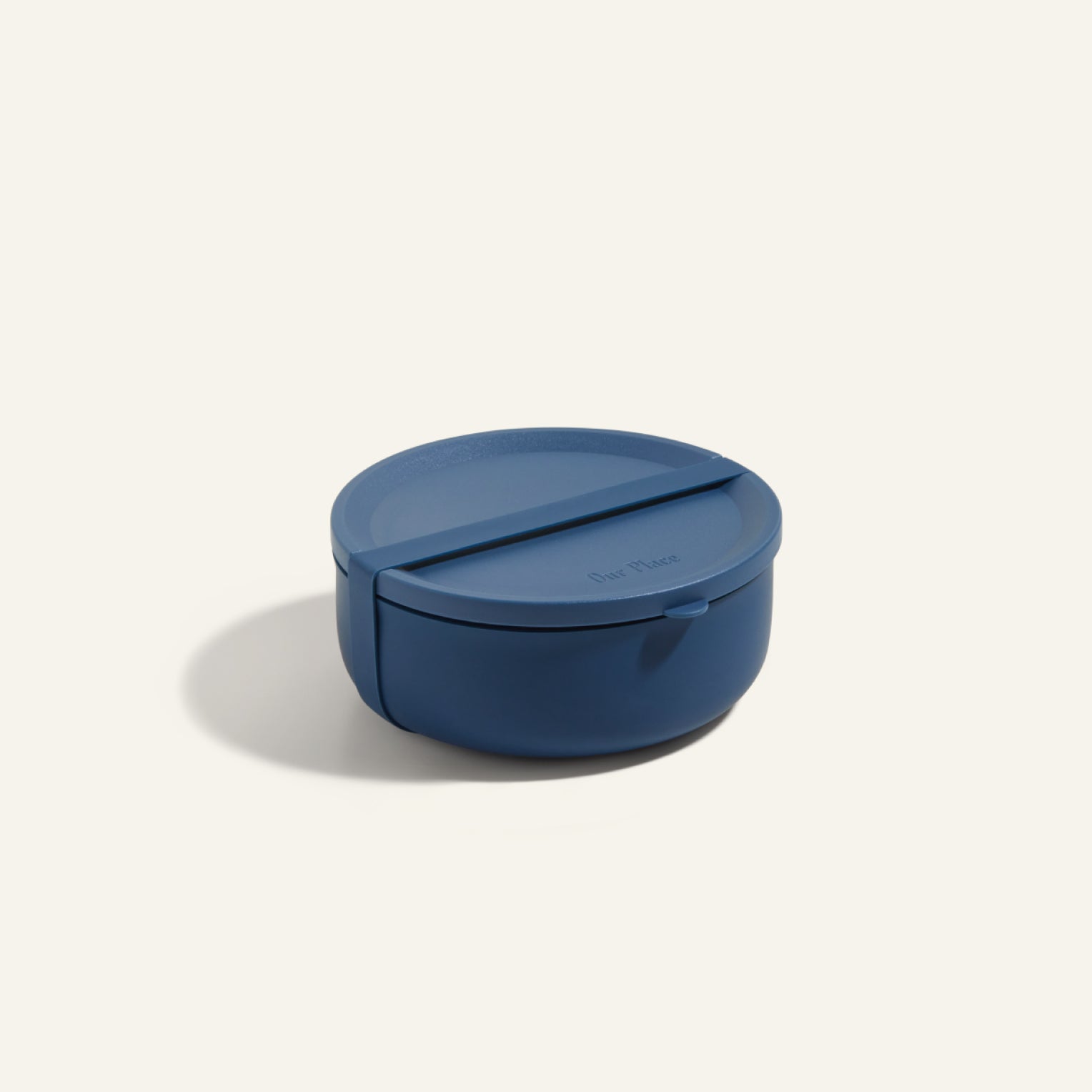 The Wander Bowl is a round, blue plastic lunch container with a fitted lid, shown against a plain background. Microwave safe, it's ideal for storing and reheating meals.