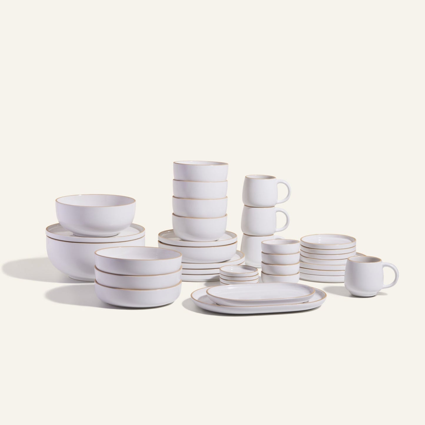 The Complete Stacking Set is a white ceramic collection of plates, bowls, mugs, and saucers arranged on a light background—ideal for upgrading your dinner party serveware.