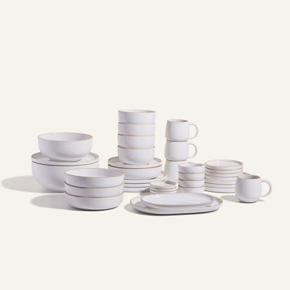 The Complete Stacking Set is a white ceramic collection of plates, bowls, mugs, and saucers arranged on a light background—ideal for upgrading your dinner party serveware.