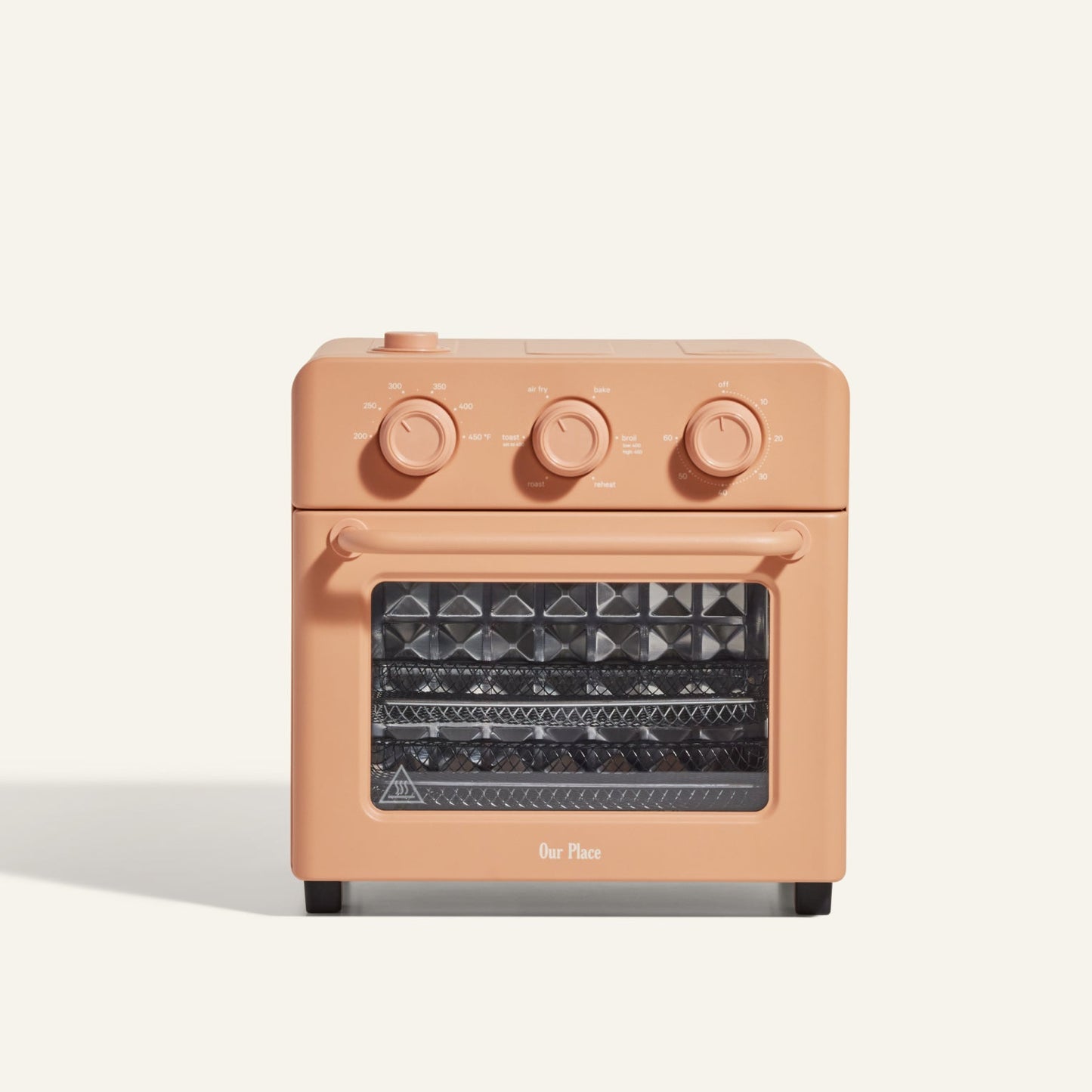 The AU - Wonder Oven is a compact, rectangular peach toaster oven with three control dials and a clear window revealing two metal racks. Ideal for countertops, it also functions as a versatile air fryer.