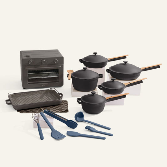 Set of black cookware including pots, pans, and utensils on a white background