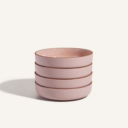 A stack of four pink, scratch-resistant Dinner Bowls sits against a plain background—stylish, stackable tableware perfect for any modern kitchen.
