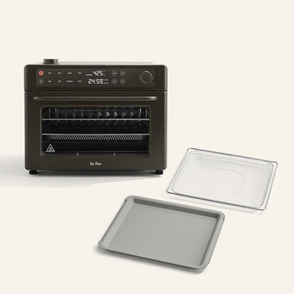 The Wonder Oven Pro + Wonder Oven Pro Essentials Kit is a black countertop air fryer oven with a digital display, shown with a wire rack and baking tray in front of it on a light background.