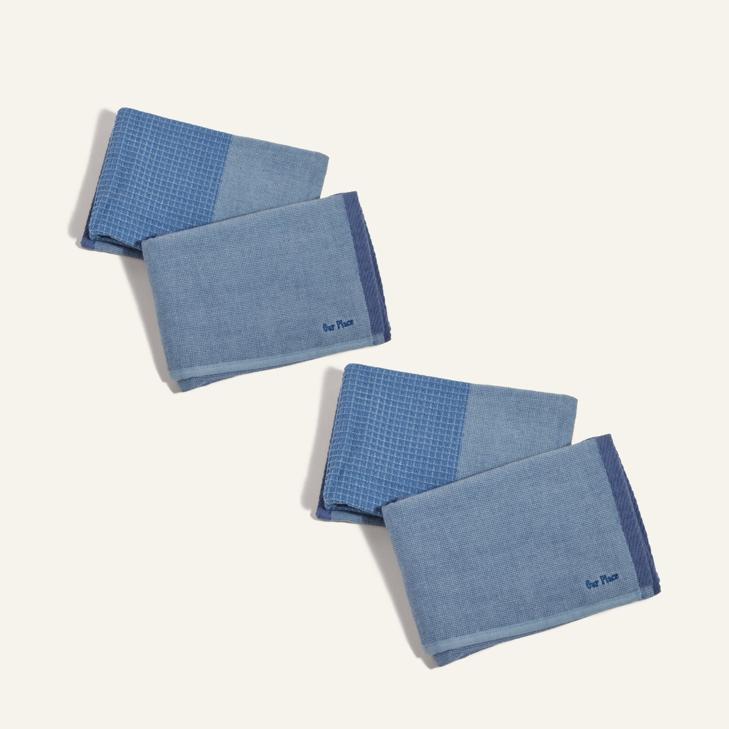 Four Double Dish Towels featuring two-tone blue patterns are folded and arranged diagonally on a light background, showcasing their dual-textured design.