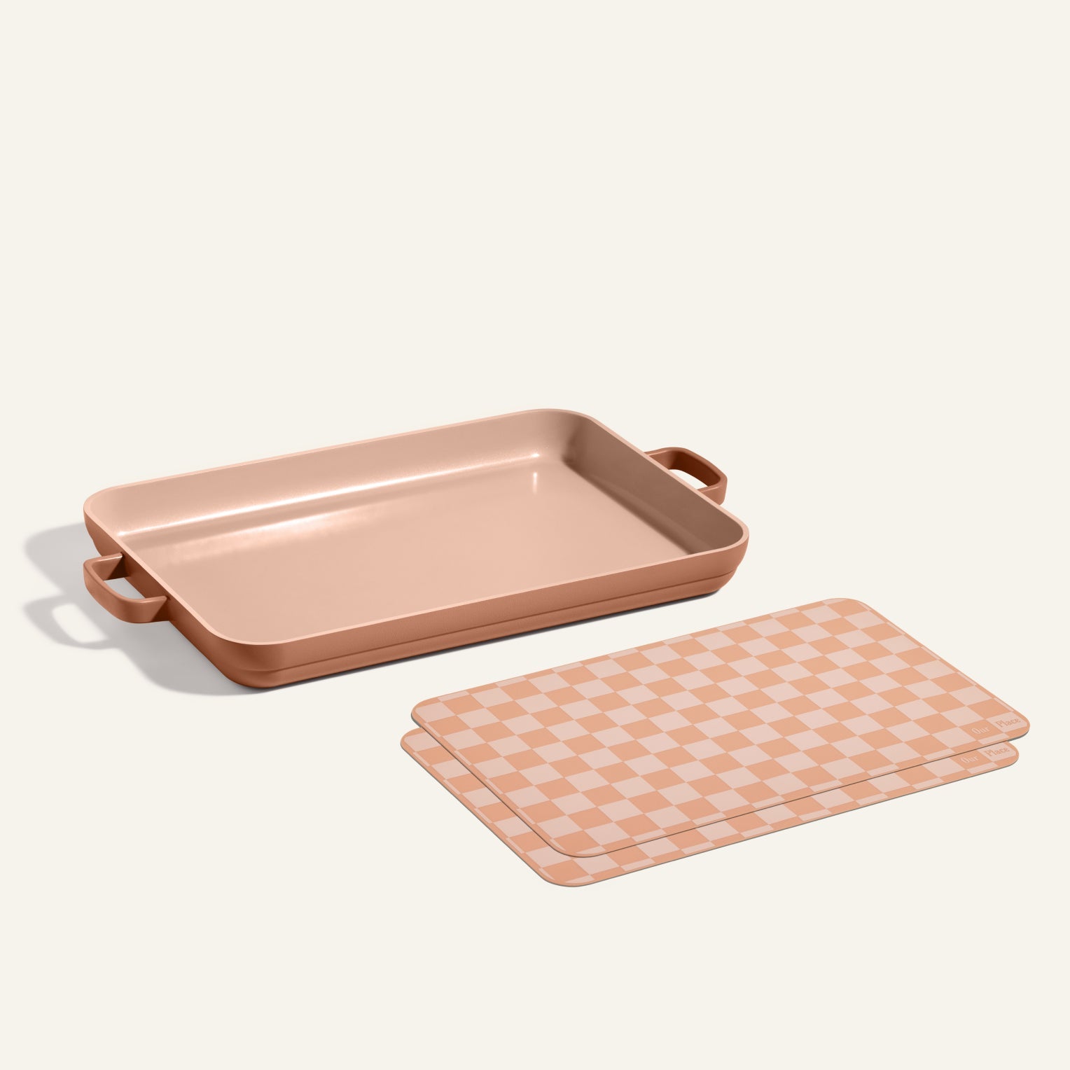 A Griddle Pan with handles is placed beside matching Oven Mats, both set on a plain background.