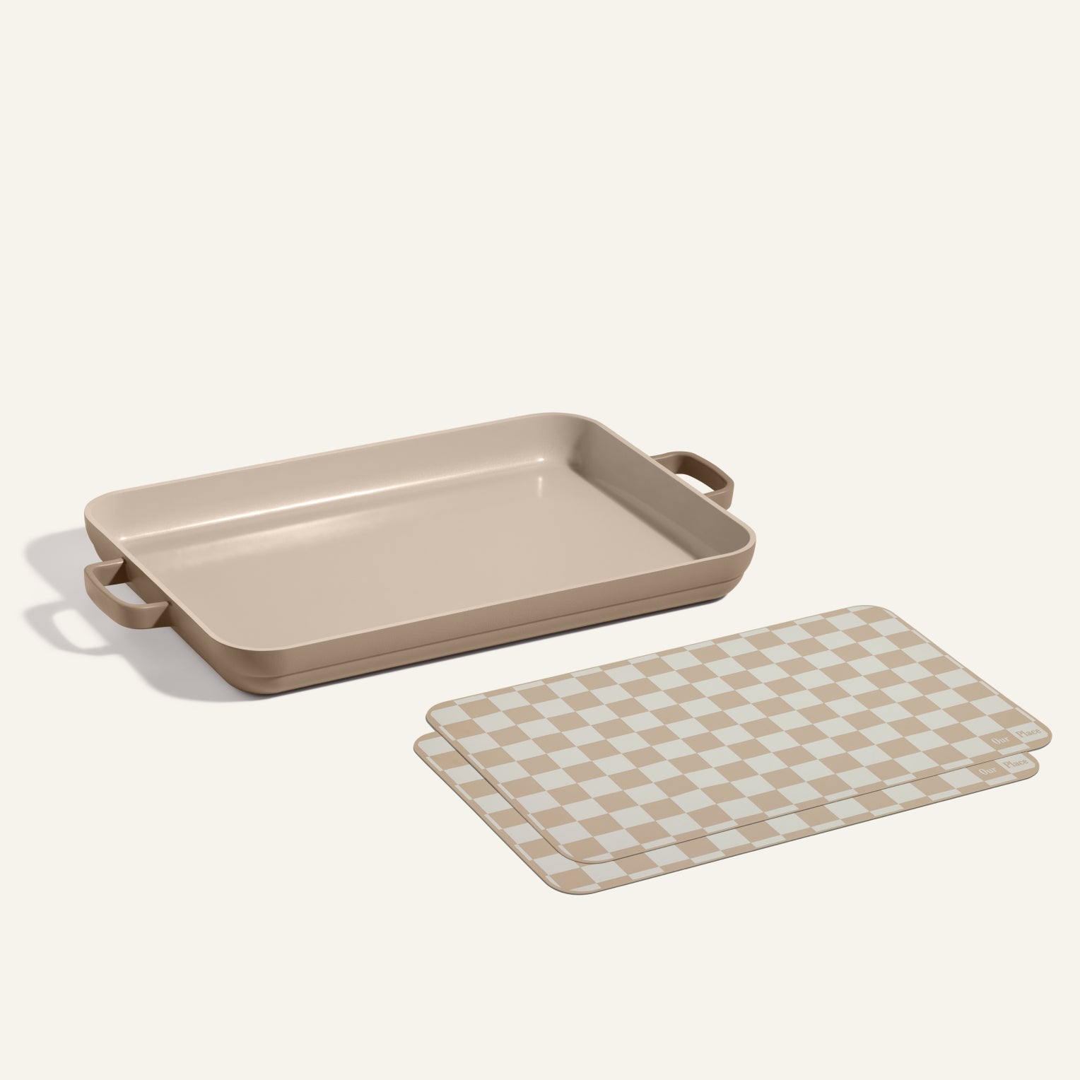A rectangular Griddle Pan with handles is placed next to two beige and white checkered Oven Mats.