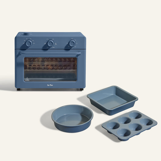 The Large Wonder Oven + Wonder Oven Baker's Kit is shown in blue with a round cake pan, square baking pan, and six-cup muffin tin, all displayed on a light background.