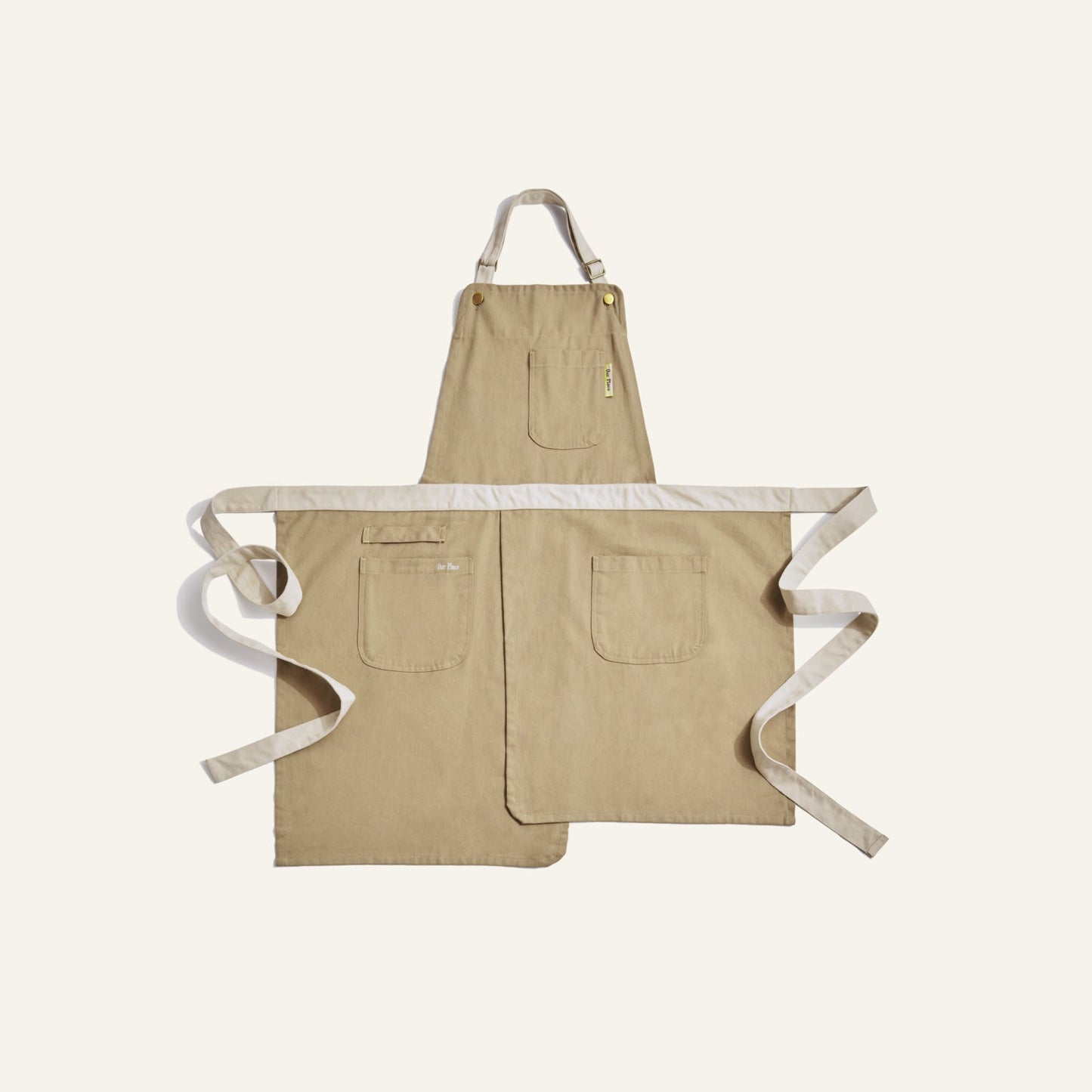 Beige apron with white straps on a light beige background