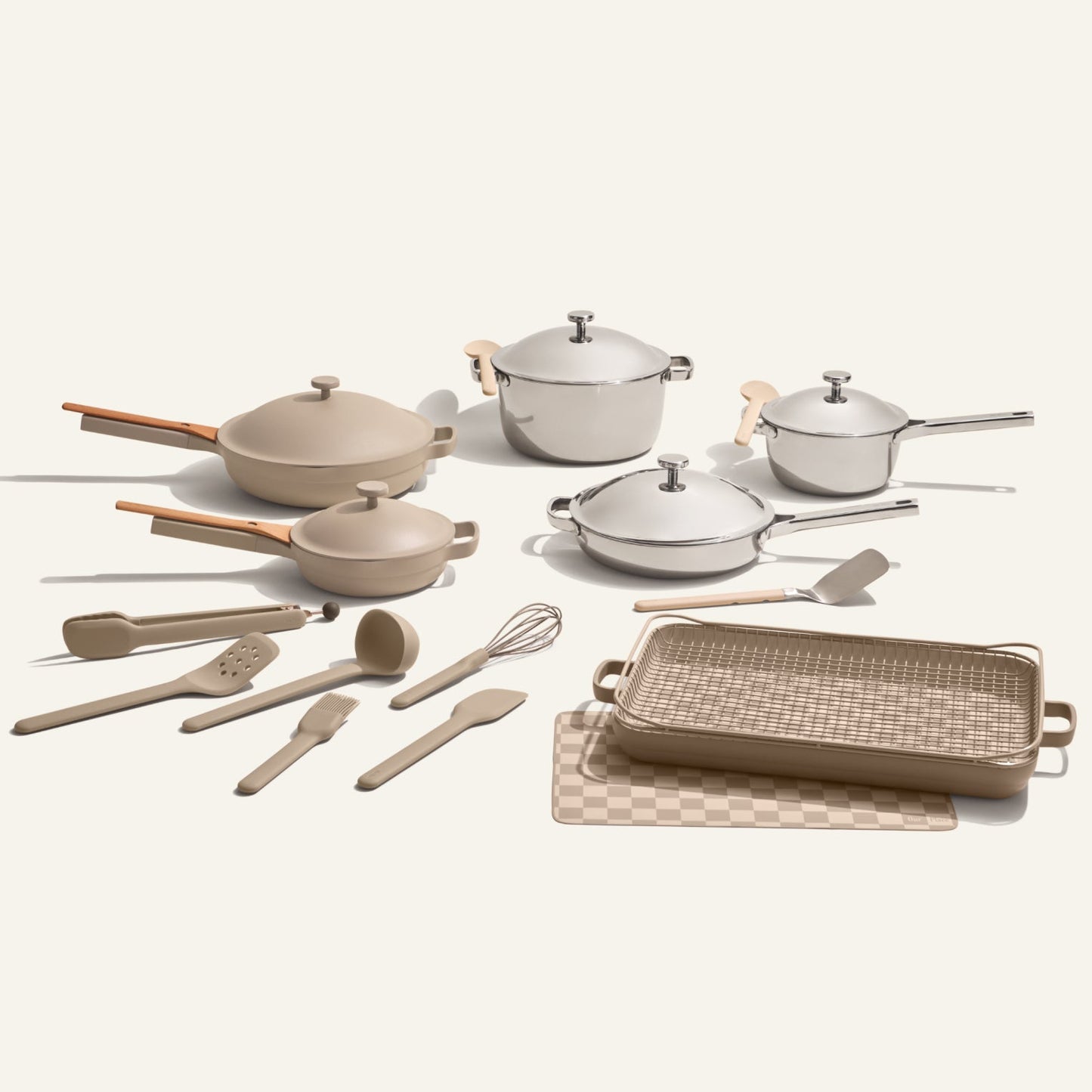 The Home Chef Set (25 piece) includes non-toxic pans, pots with lids, cooking utensils, a baking dish, and a checkered cutting board—all in neutral beige and white tones.