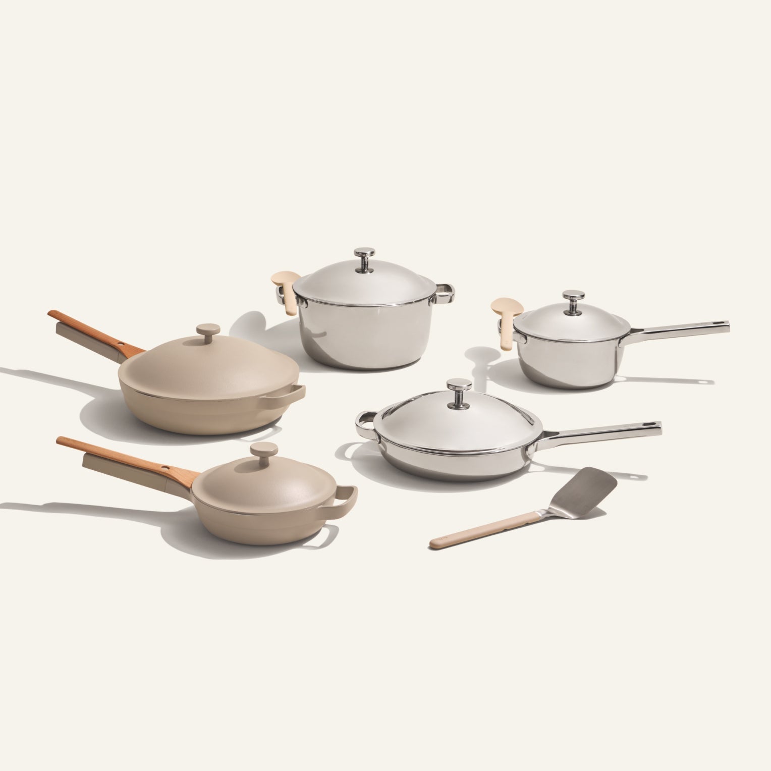 The Home Chef Set (15 piece) includes versatile beige and stainless steel pots, pans with lids, and wooden utensils, all arranged on a plain light background.