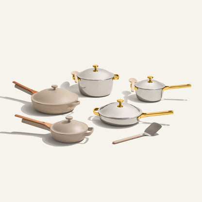 The Home Chef Set (15 piece) includes versatile pots, pans, matching lids, and a metal spatula, all arranged on a plain light background.
