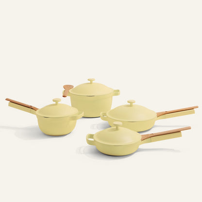 Set of yellow cookware with wooden handles on a white background
