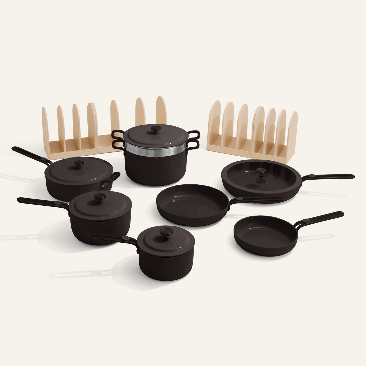Set of black cookware with lids and wooden racks on a white background