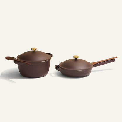 The Cookware Duo includes a brown nonstick pot with lid and spoon, plus a frying pan with lid, all featuring stylish gold handles—an ideal set to upgrade your old cookware.