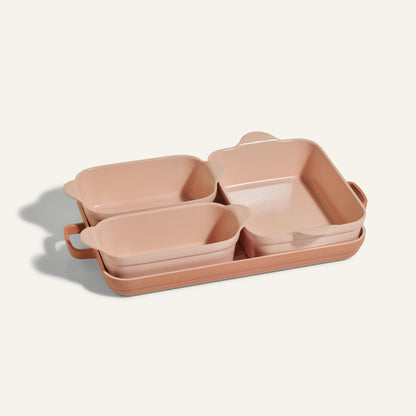 The Bakeware Set includes four pink ceramic baking dishes in different sizes, neatly nested together on a light background, offering both style and practicality for your kitchen.