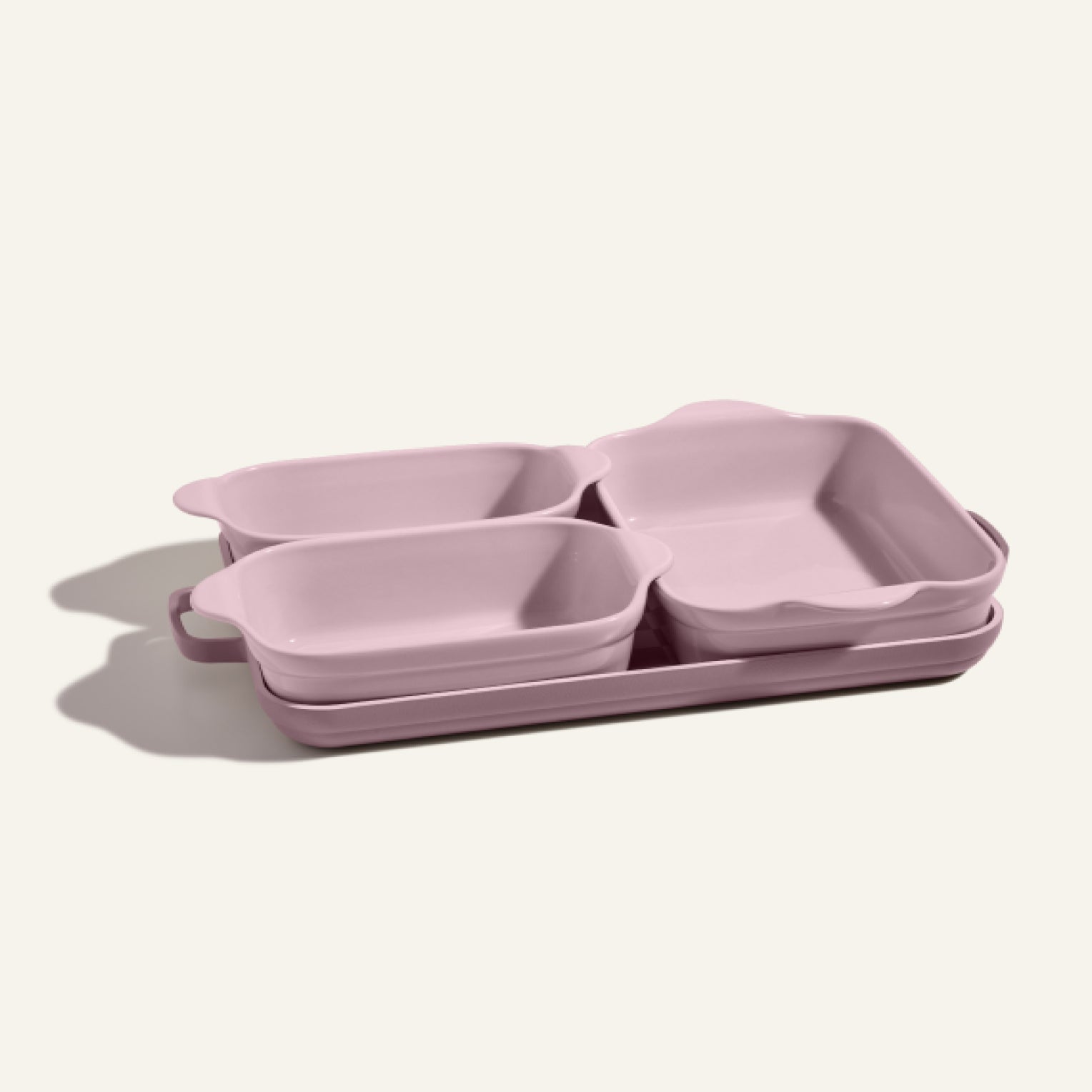 The Bakeware Set includes four pink ceramic baking dishes—two small and two large—designed for a stylish kitchen and shown neatly stacked on a light surface.