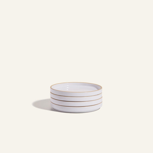 Four stacked Dessert Plates, crafted from white ceramic with thin gold rims and scratch-resistant finish, are elegantly displayed on a light, neutral background.